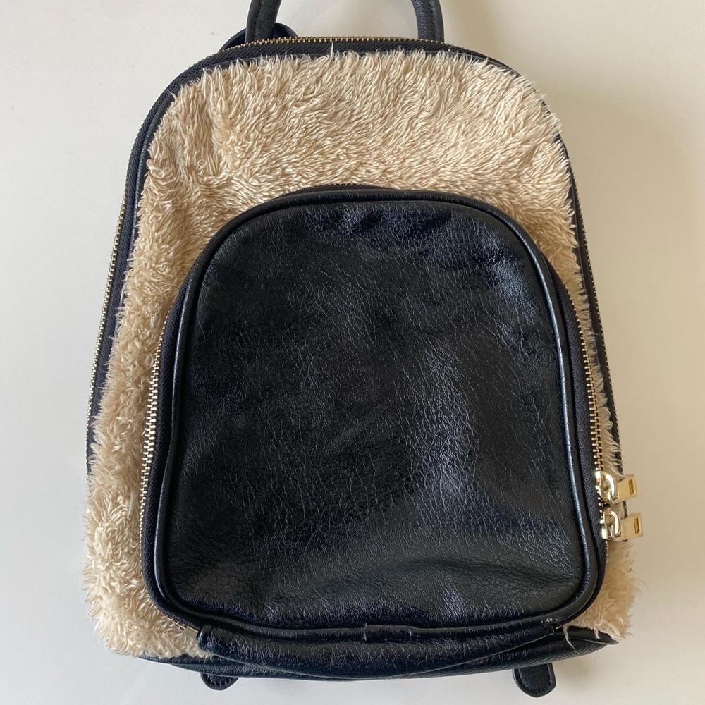 Black and fur backpack purse with gold zippers.